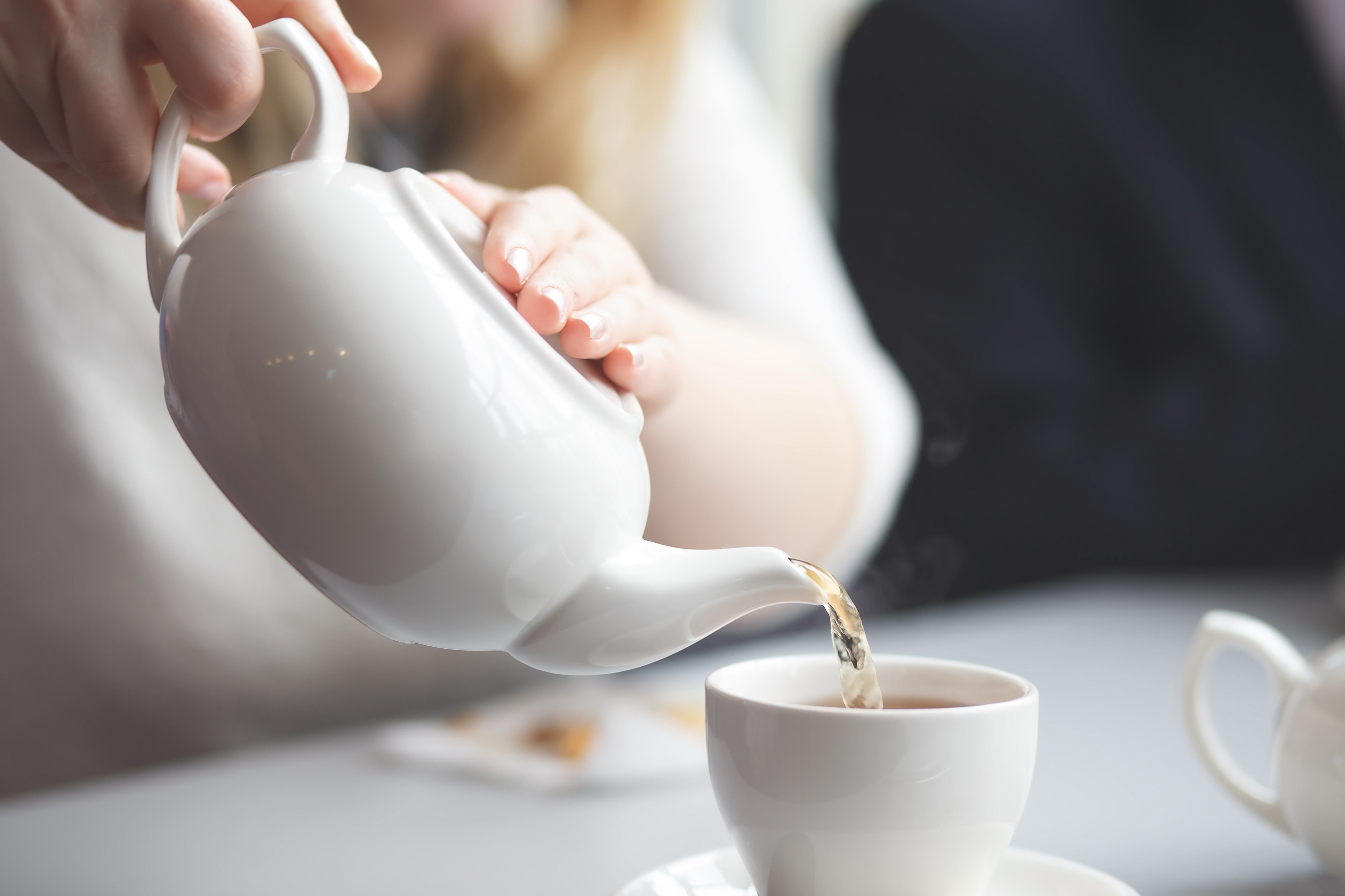 side view of a female pouring tea